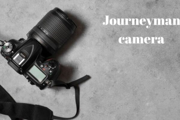 A journeyman camera placed on a rustic wooden table surrounded by photography accessories.