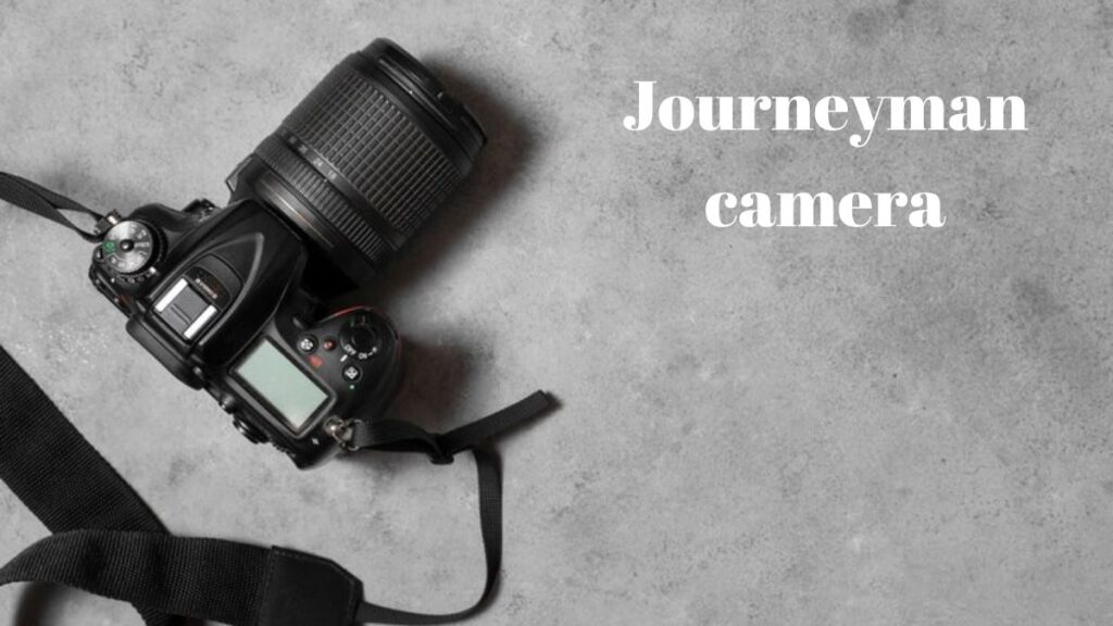 A journeyman camera placed on a rustic wooden table surrounded by photography accessories.